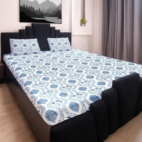o0pC4MlyhH2_zxutg8kMq2Ta.jpg A neatly made king size bed with a white bedsheet featuring a blue botanical print, accompanied by two matching pillow covers, set against a modern bedroom backdrop.